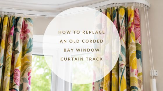 Corded aluminium bay window curtain track with bright patterned curtains in a modern home.