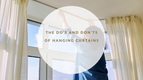Woman hanging curtains at a window